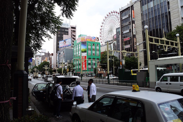 タクシーのトランクに自転車を積み込もうと頑張っている