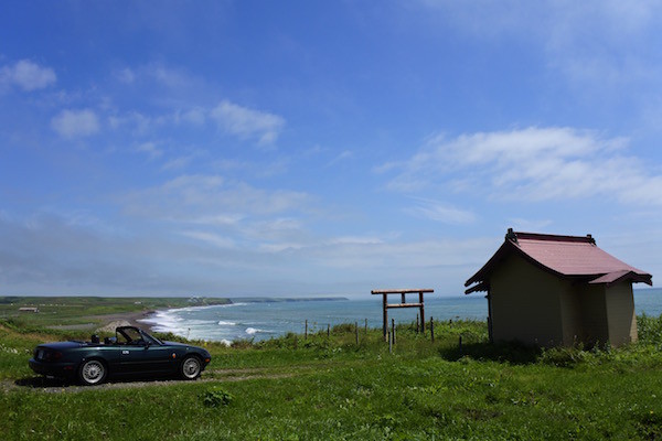 鳥居と祠が望む海岸線と青い空
