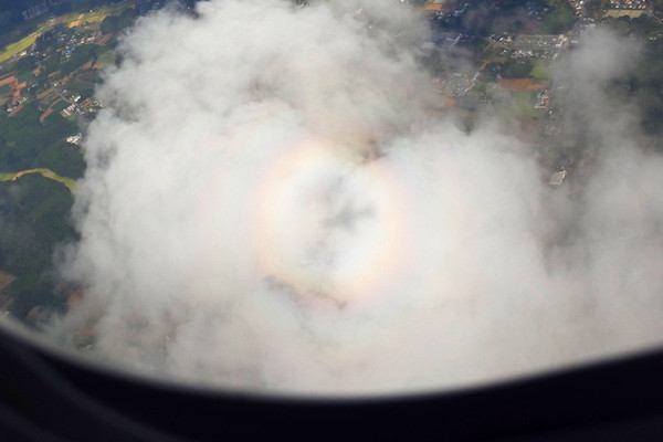 上の写真を拡大、トリミングしたまん丸の虹と飛行機の影